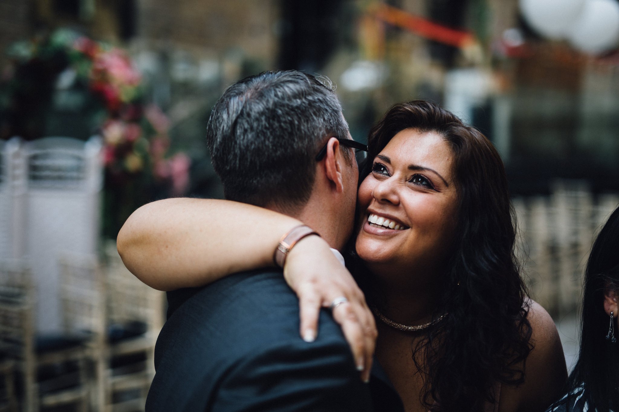  Wedding guest hugs the groom with a smile on her face 