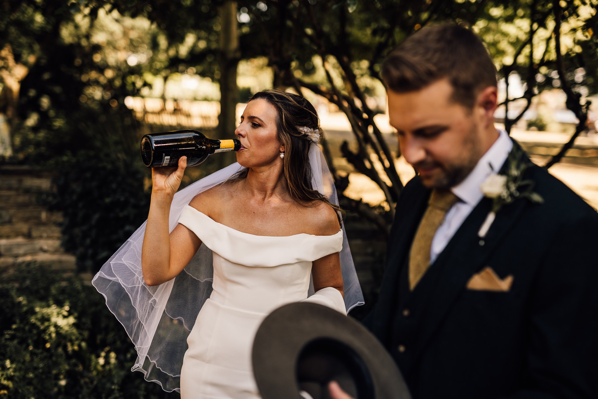  Bride drinks from a bottle of wine 