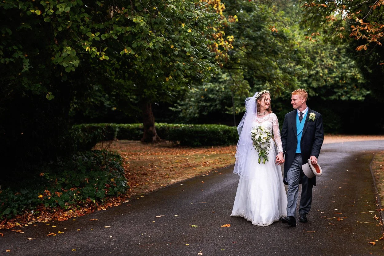 Bride and Groom walk through the grounds of The Tudor Barn