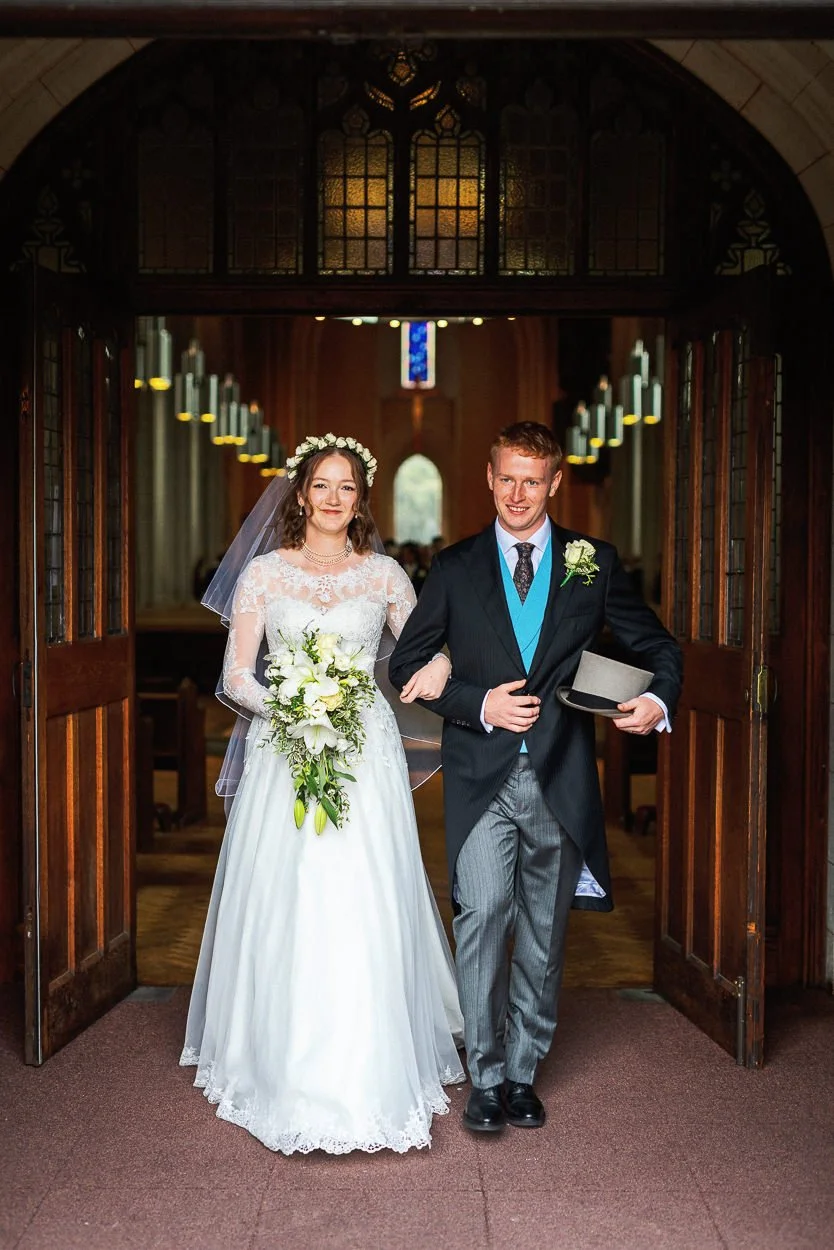 Bride and Groom walk out of Ealing Abbey arm in arm