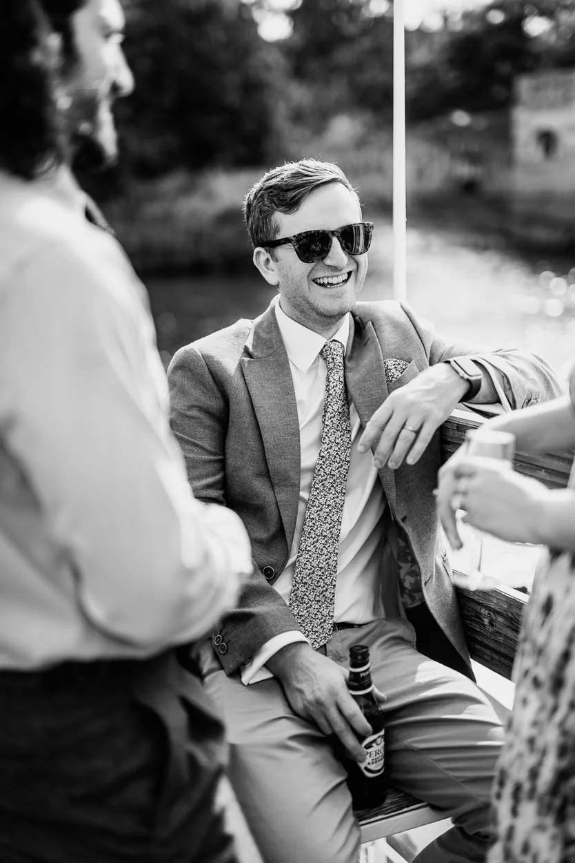 Wedding guest smiling on a boat on the thames