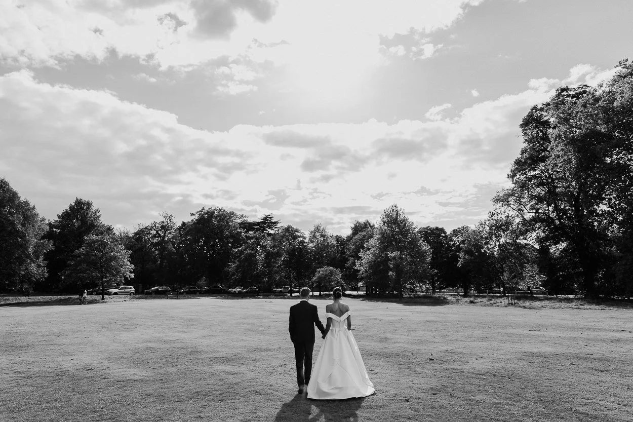 Bride and Groom walking across Ealing Common after their ceremony at the Brentham Club
