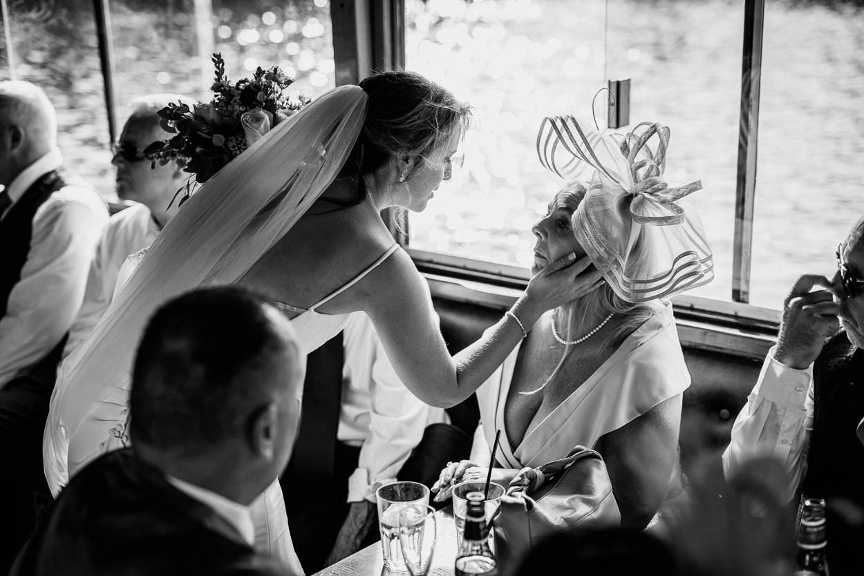 Bride puts her hand on her mothers cheek