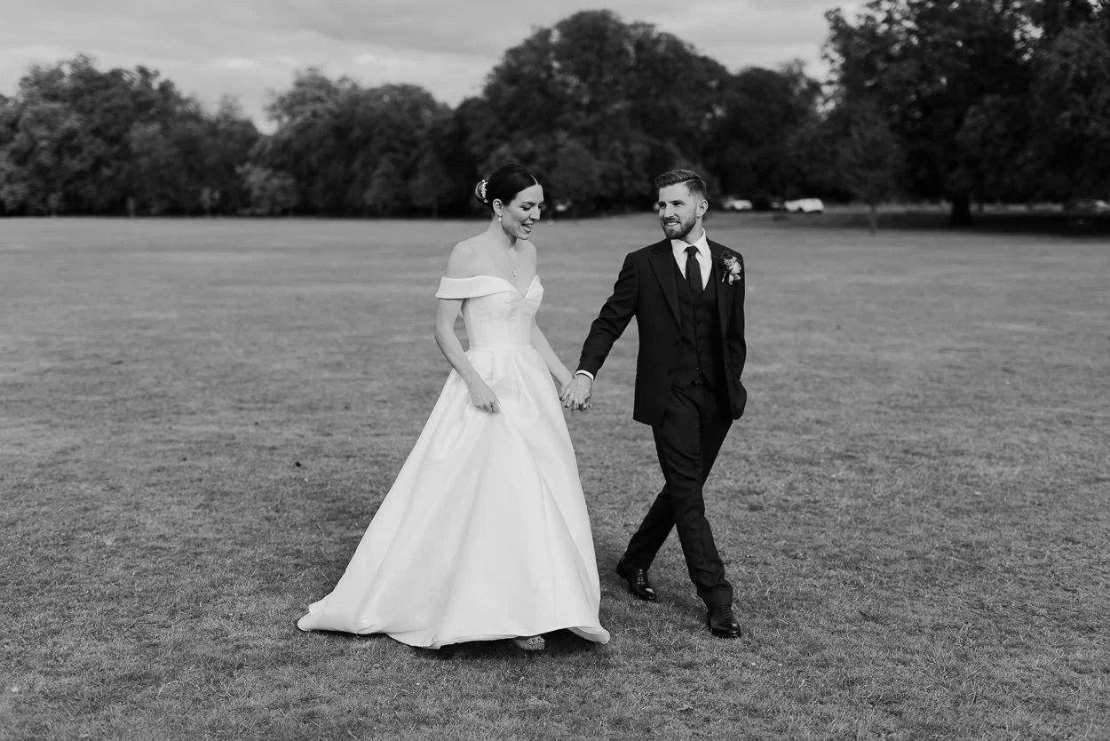 Wedding couple walk across Ealing common