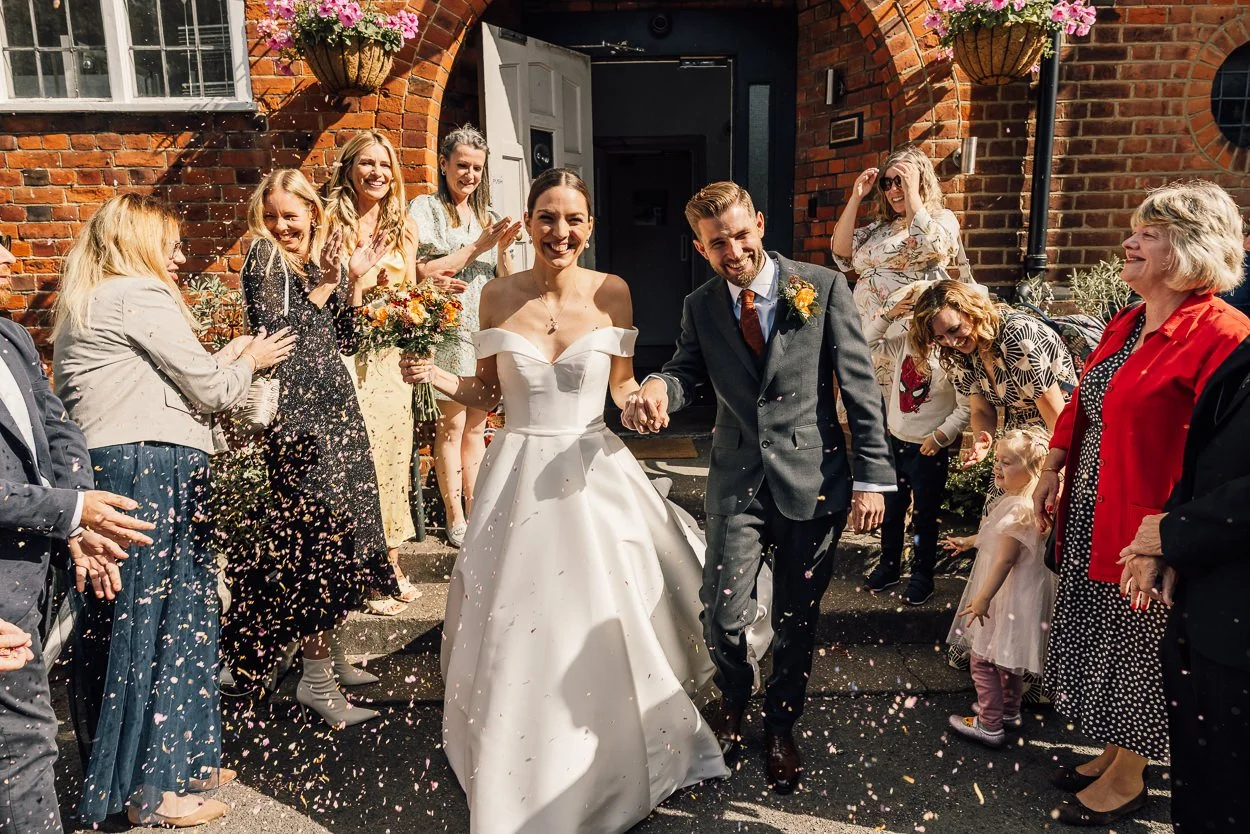 Bride and Groom have confetti thrown at them at the Brentham club