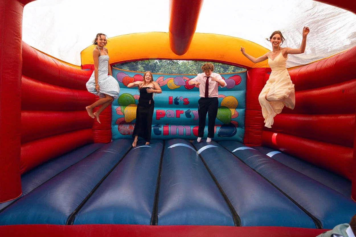 Wedding guests jumping on bouncy castle
