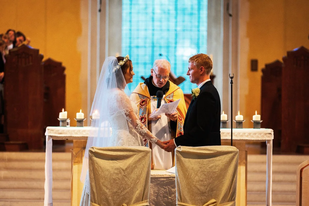 The couple holding hands during the ceremony