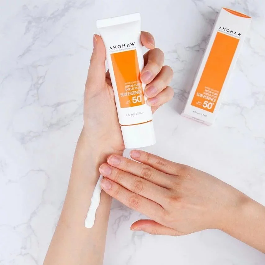 Ahohaw Inten-Cure Sun Essence being swatched on a woman's wrist and showing how lightweight and watery the sunscreen is