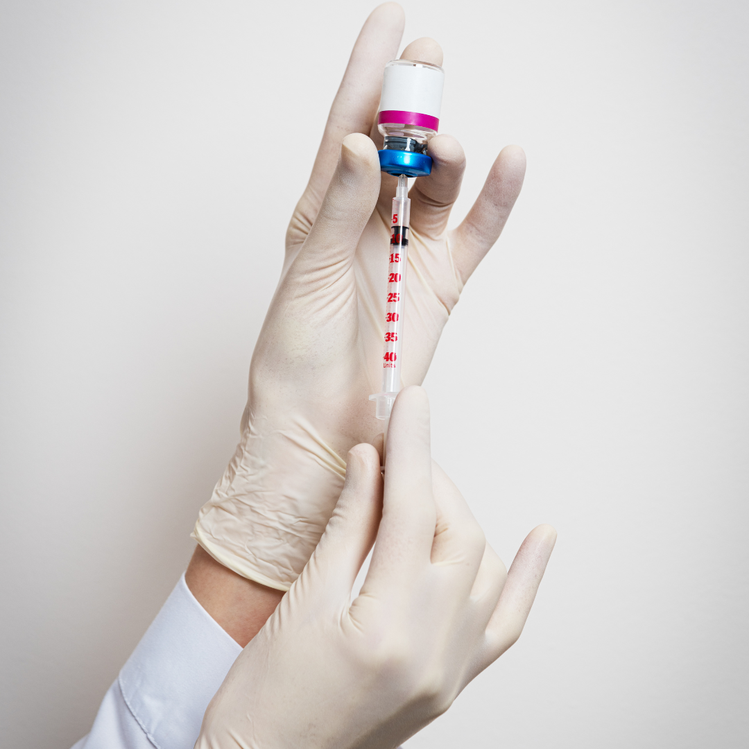 White gloved hands extracting Botox from a vial into a needle