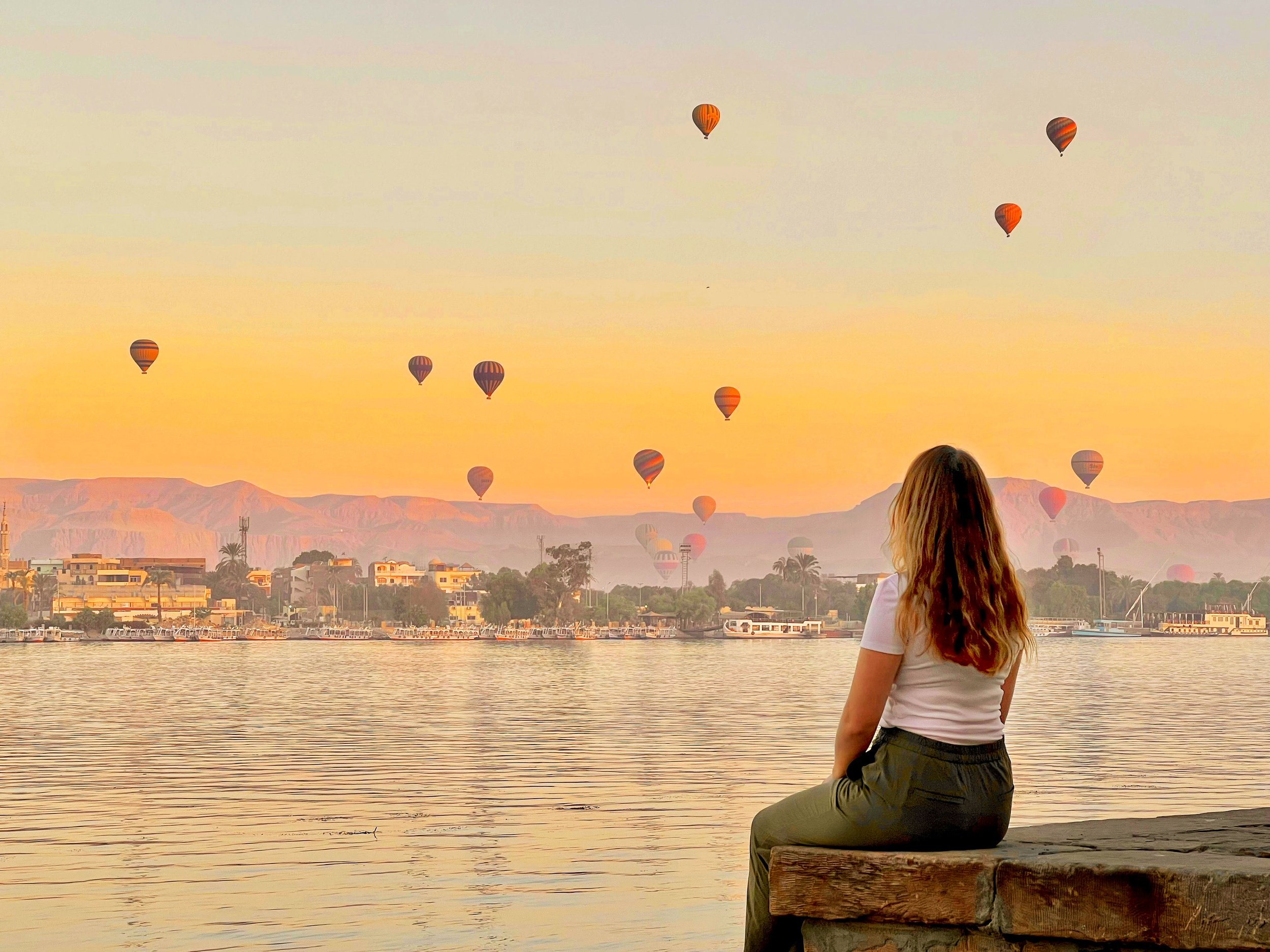 Luxor at sunrise with hot air balloons in the distance