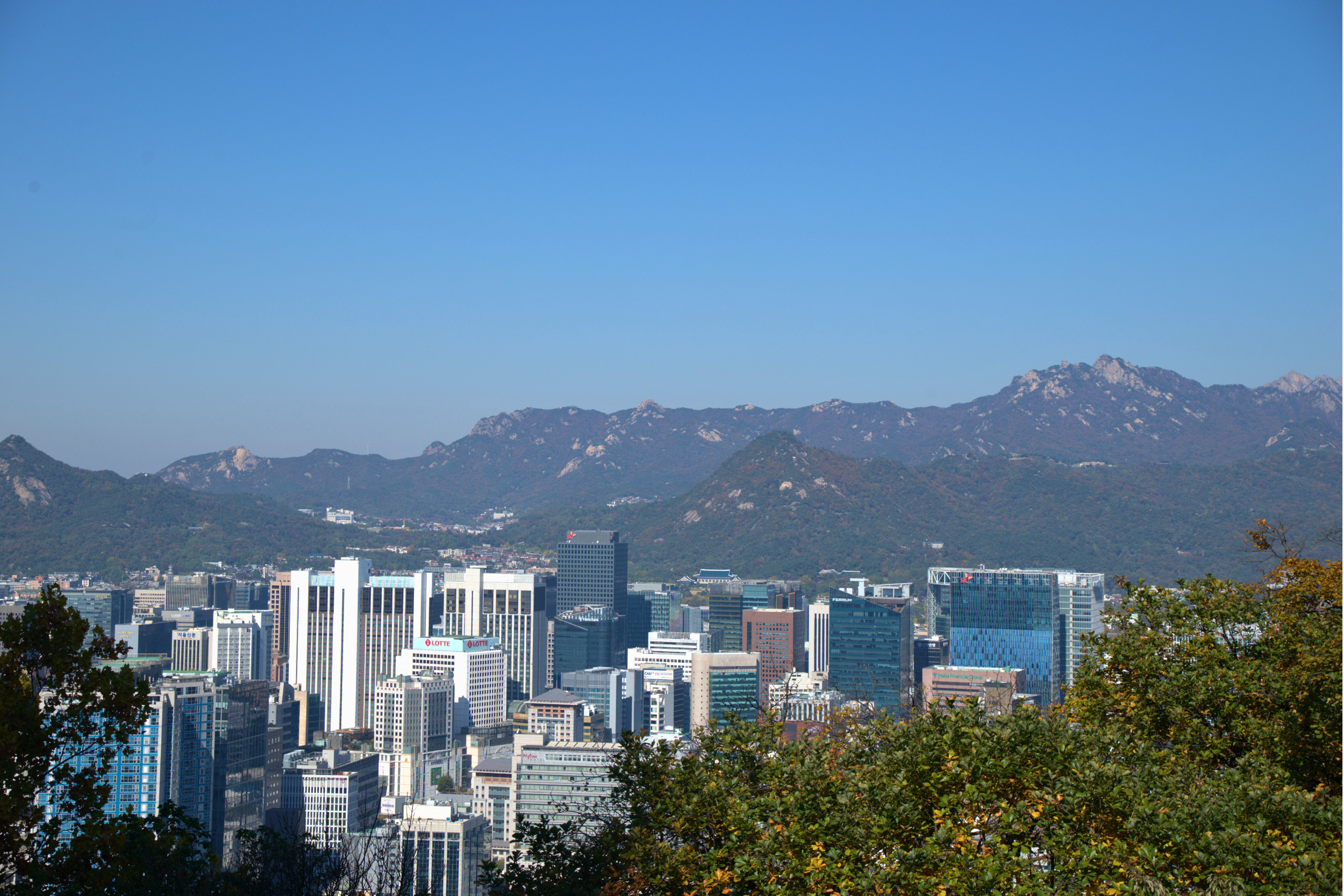 Seoul South Korea cityscape with modern skyscrapers and traditional hanok rooftops and mountain views from a rooftop