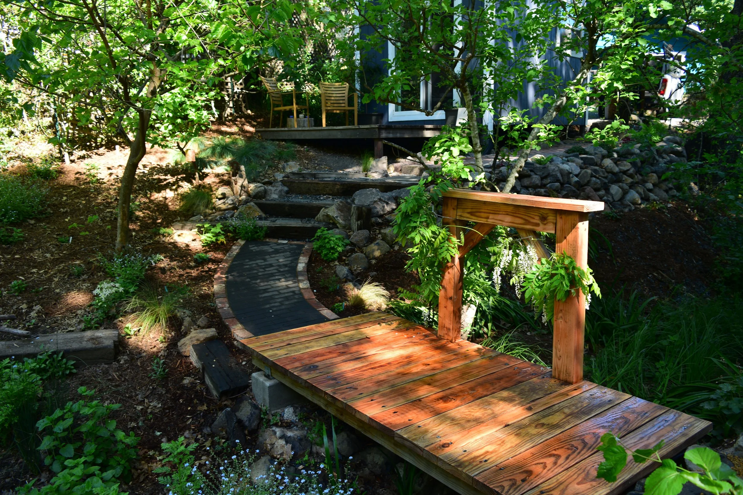 beautiful paver pathway going to a foot bridge