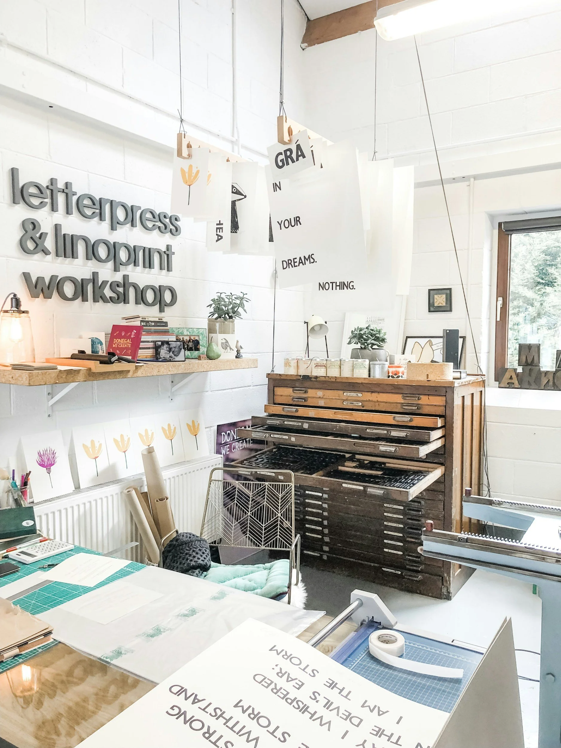 Letterpress workshop with type drawers, hanging prints and a workbench