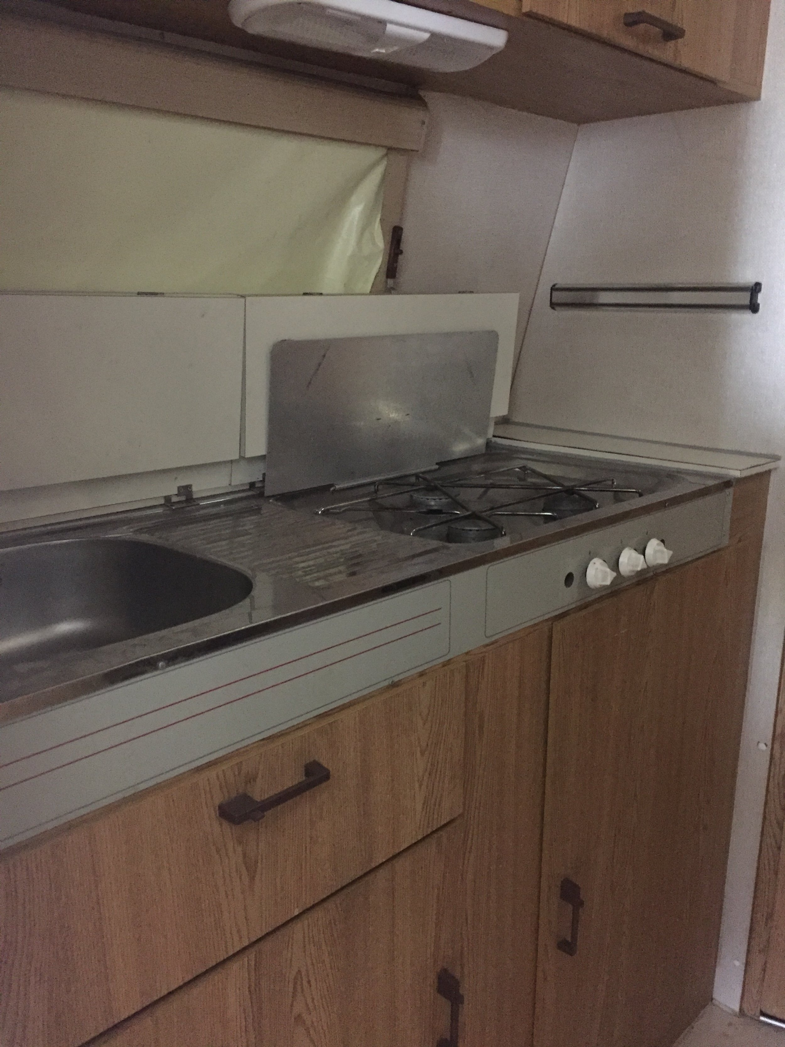 Before. Kitchen area with overhead cupboards that were later removed.