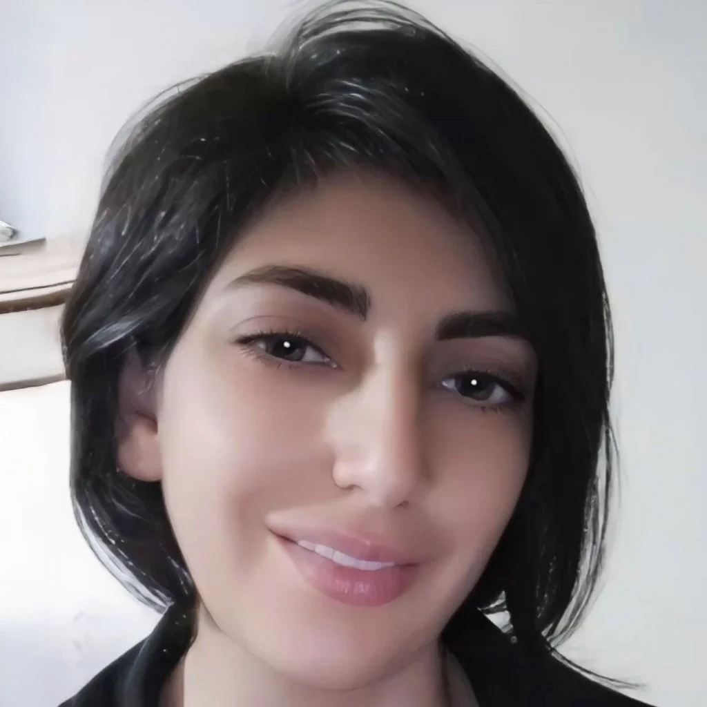 Close-up of a woman with short, dark hair, light makeup, and a slight smile.