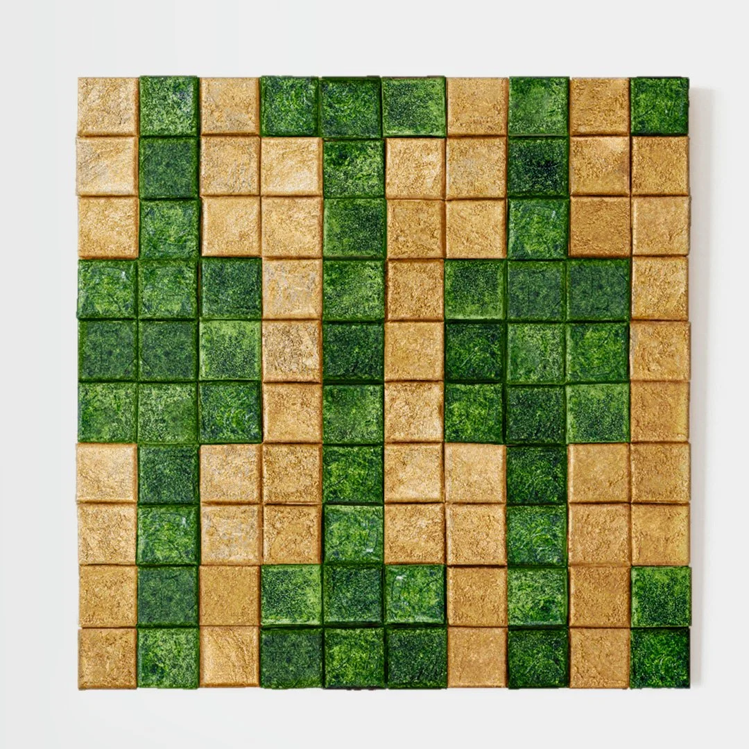 A decorative wall composed of square tiles in alternating green and tan colors, arranged in vertical columns.