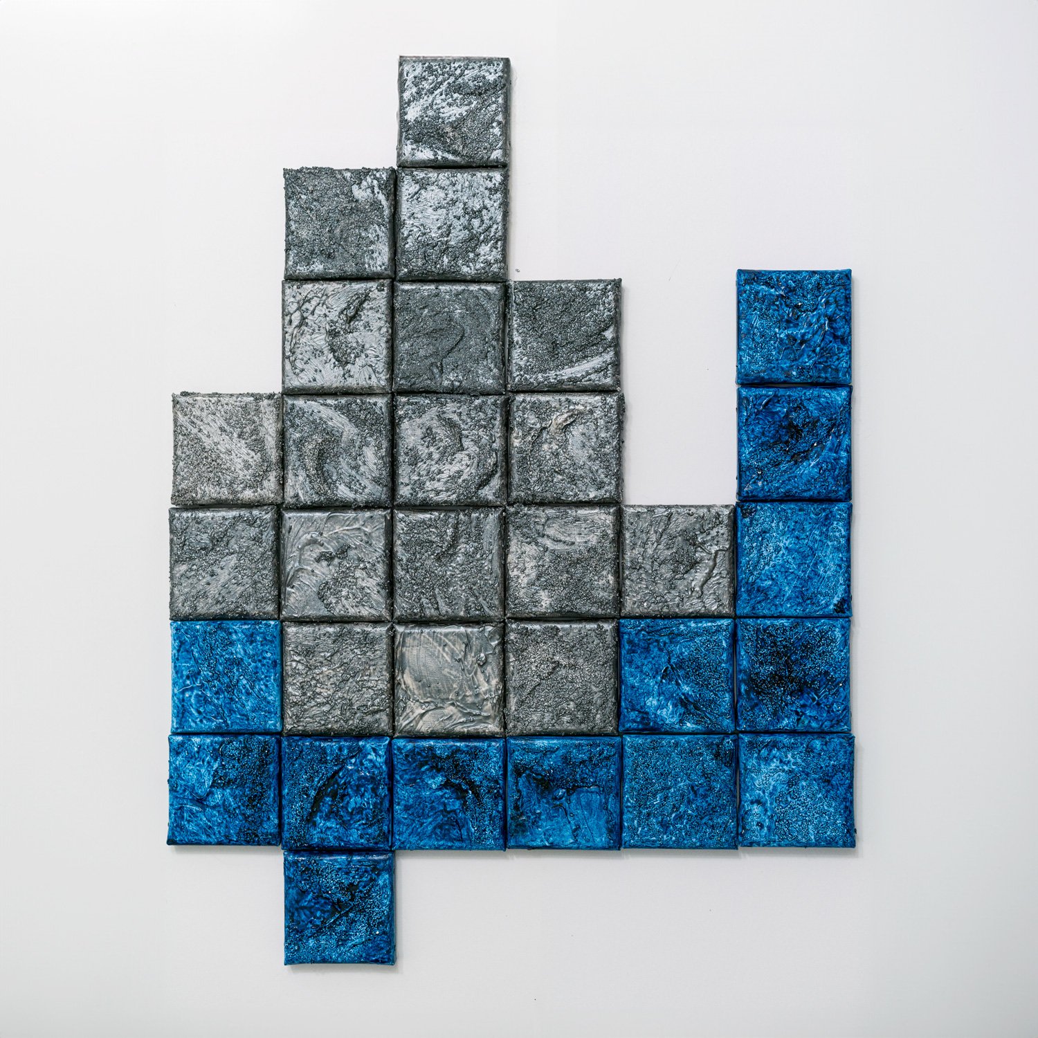 A bar graph made of square blocks, with gray blocks forming an upward trend, and a shorter column of blue blocks on the right side.