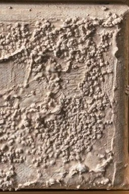 Close-up of a textured, rough stucco surface on a building corner.