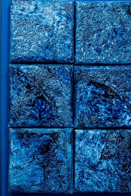 Close-up of six blue textured tiles arranged in two columns and three rows.