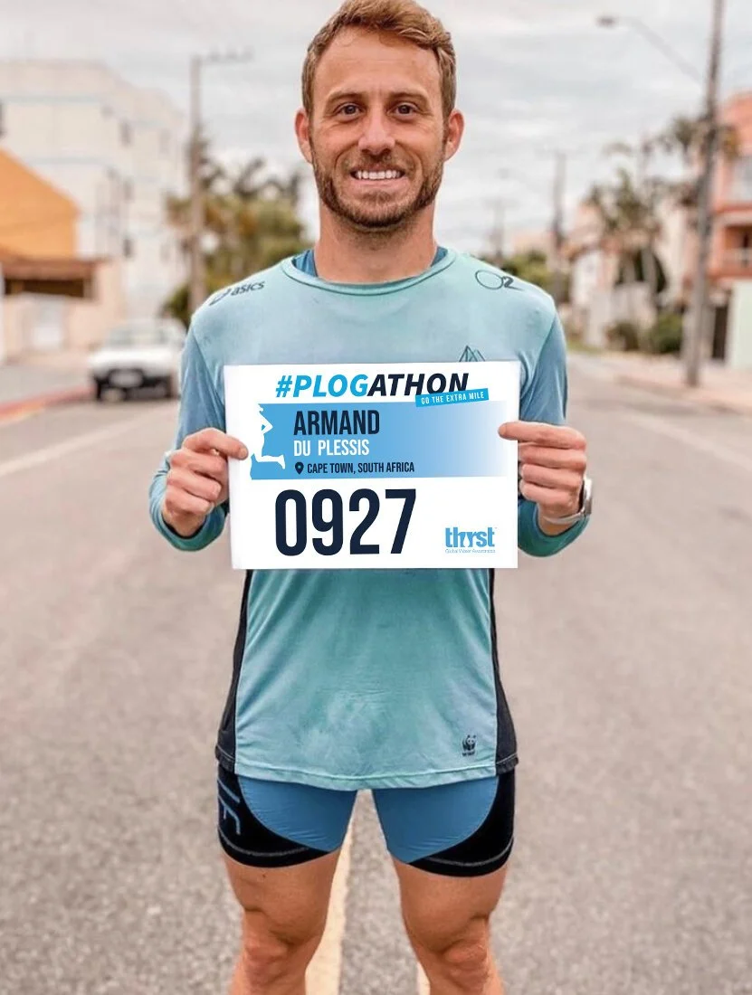 Runner holding #Plogathon race number 0927 on street in Cape Town.