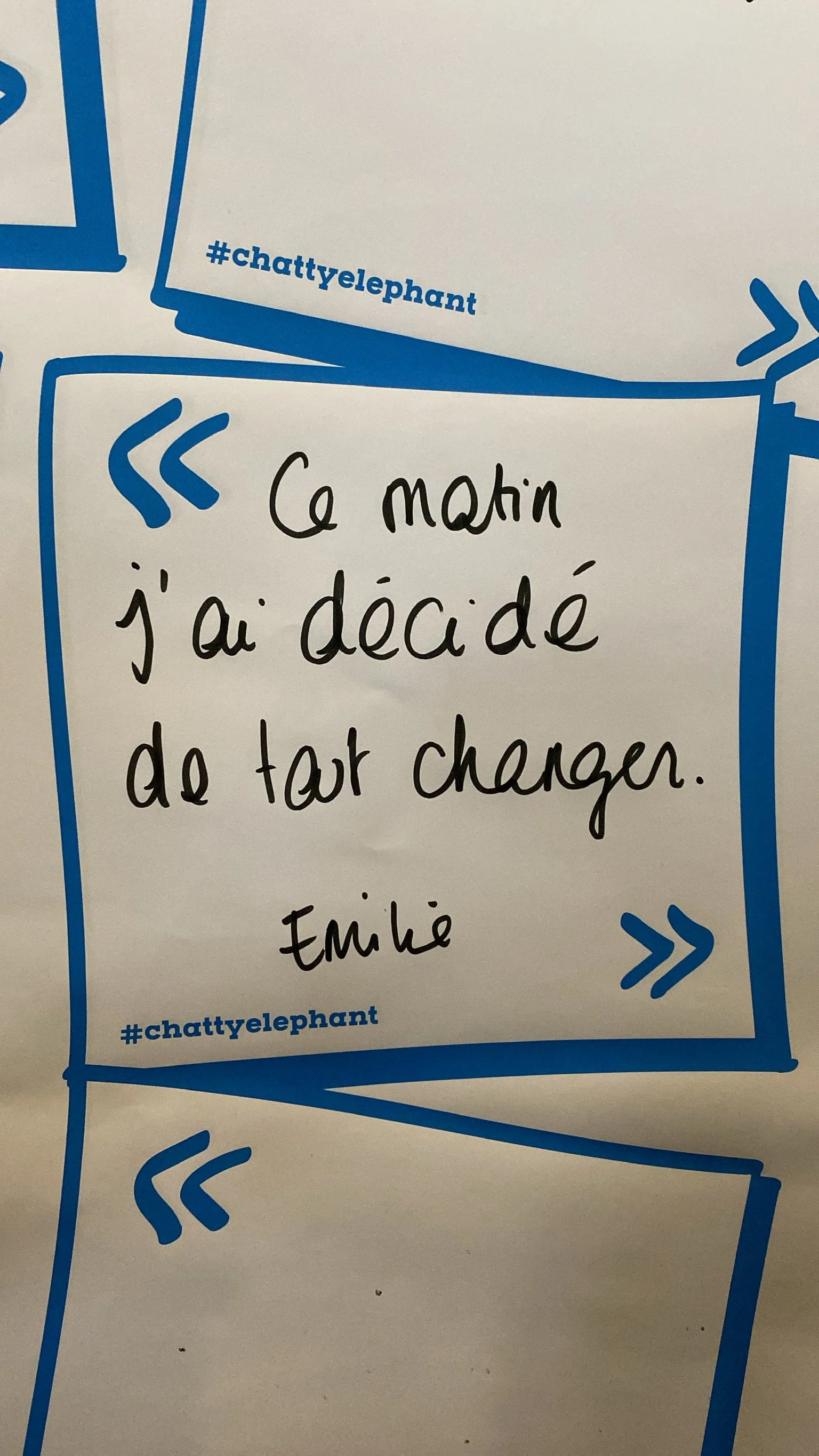 Une note manuscrite sur un fond blanc avec des cadres bleus, dit : 'Ce matin j'ai décidé de tout changer. Emile'.