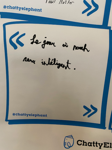 Une note manuscrite dans une feuille blanche dans un cadre bleu, avec le texte en français "Le jeu à moon sera intelligent."