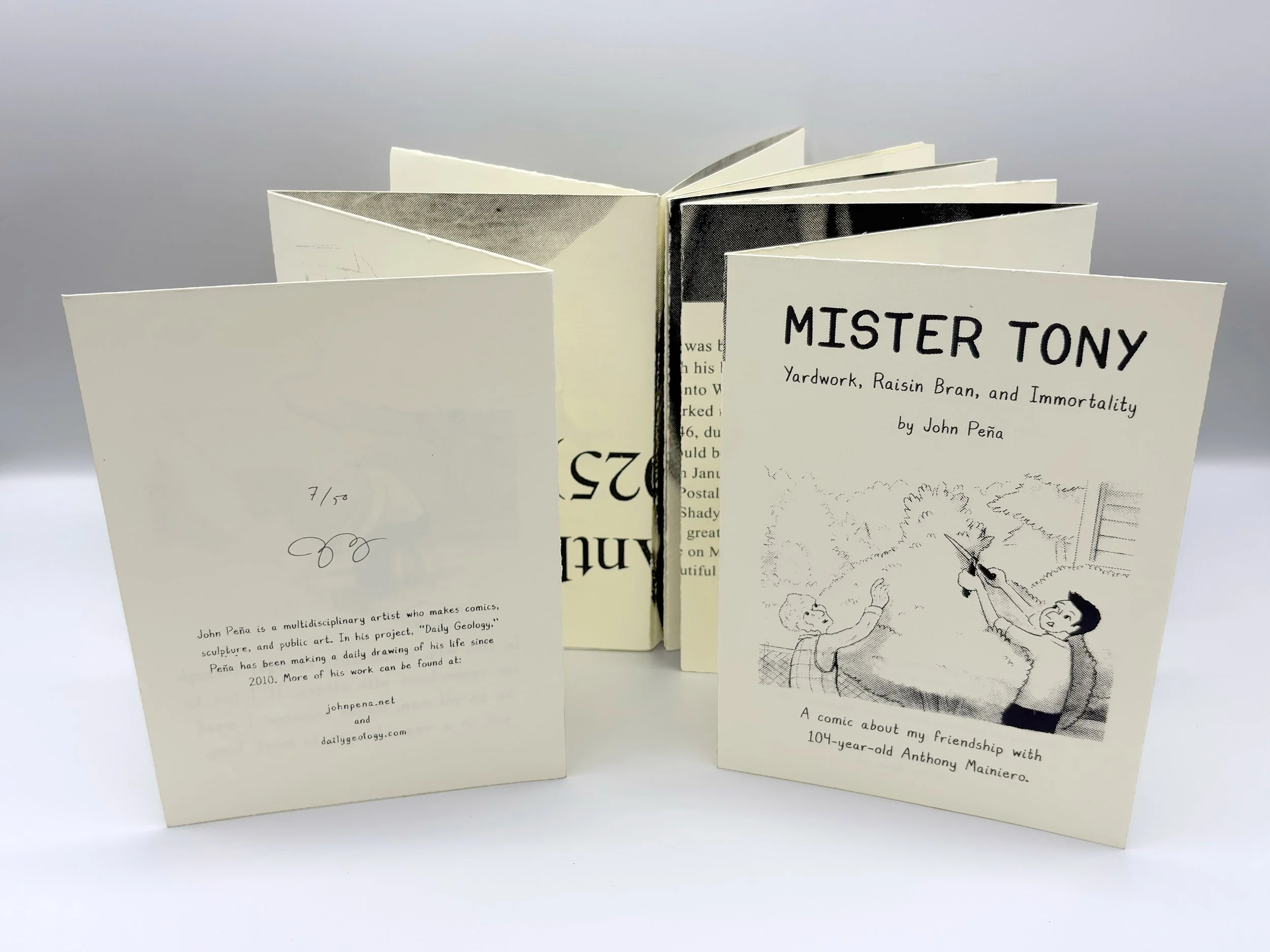 Book is opened up to reveal complex interior black and white portrait.