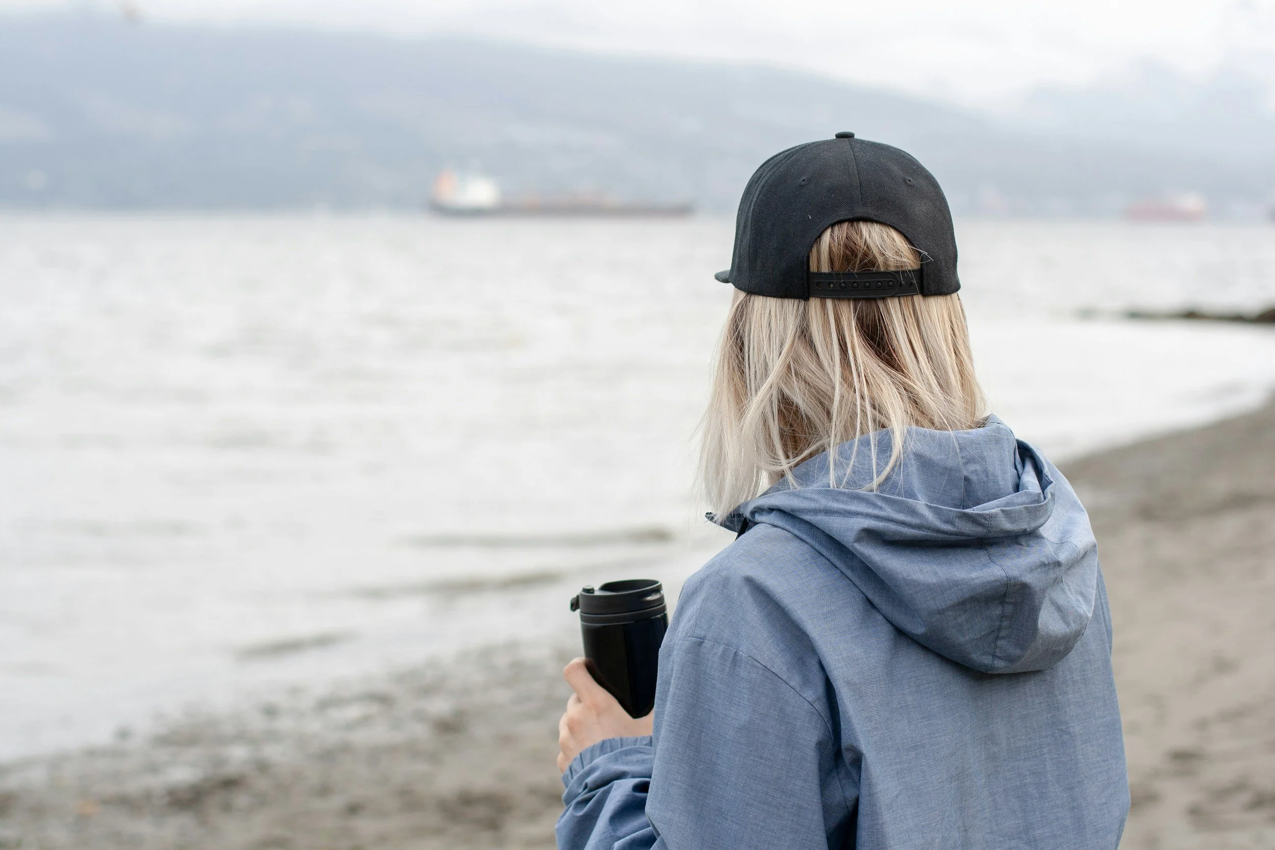 Woman sitting peacefully by water, reflecting on God's grace and letting go of perfectionism.