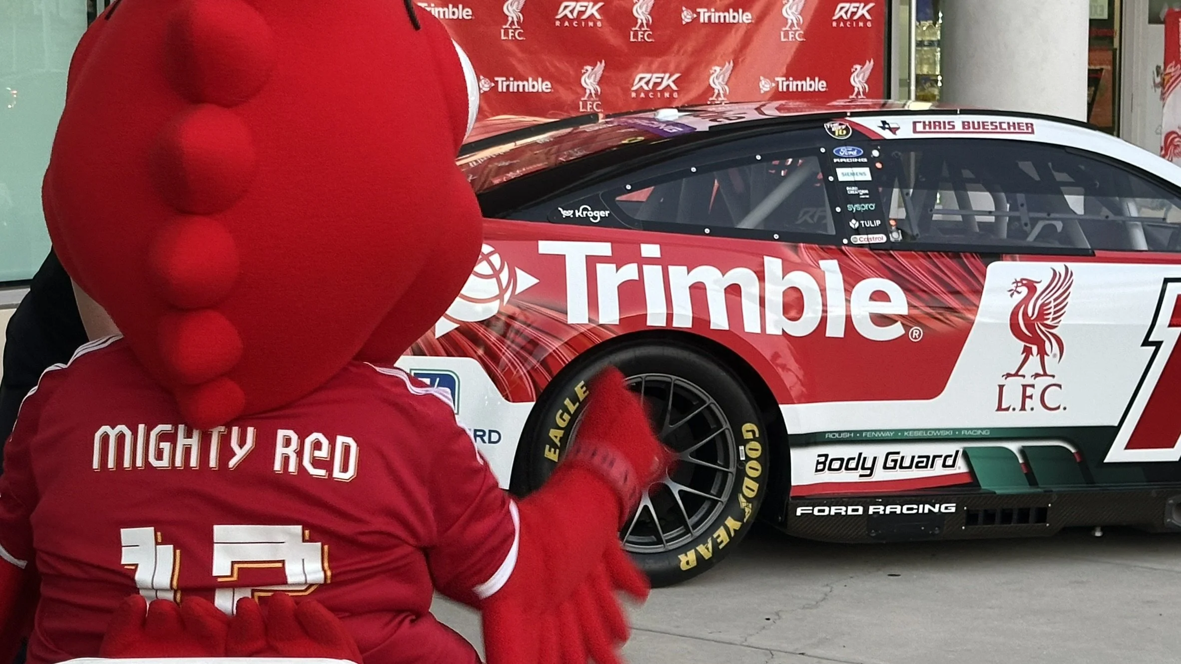 Liverpool FC Mascot Mighty Red with Nascar Cup Series RFK Racing Trimble LFC Ford Mustang Dark Horse Number 17 Driven by Chris Buescher at Sonoma Raceway Liverpool Official Supporters Club of Tampa Bay OLSC