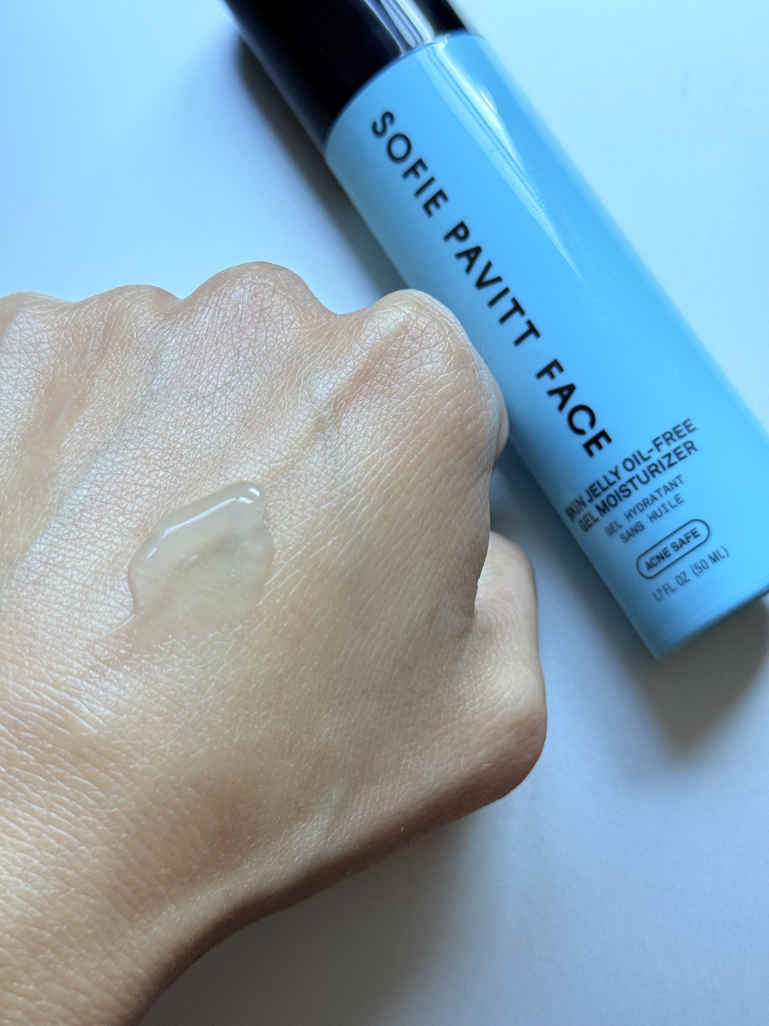 Sofie Pavitt Face Skin Jelly gel swatch beside its blue pump bottle