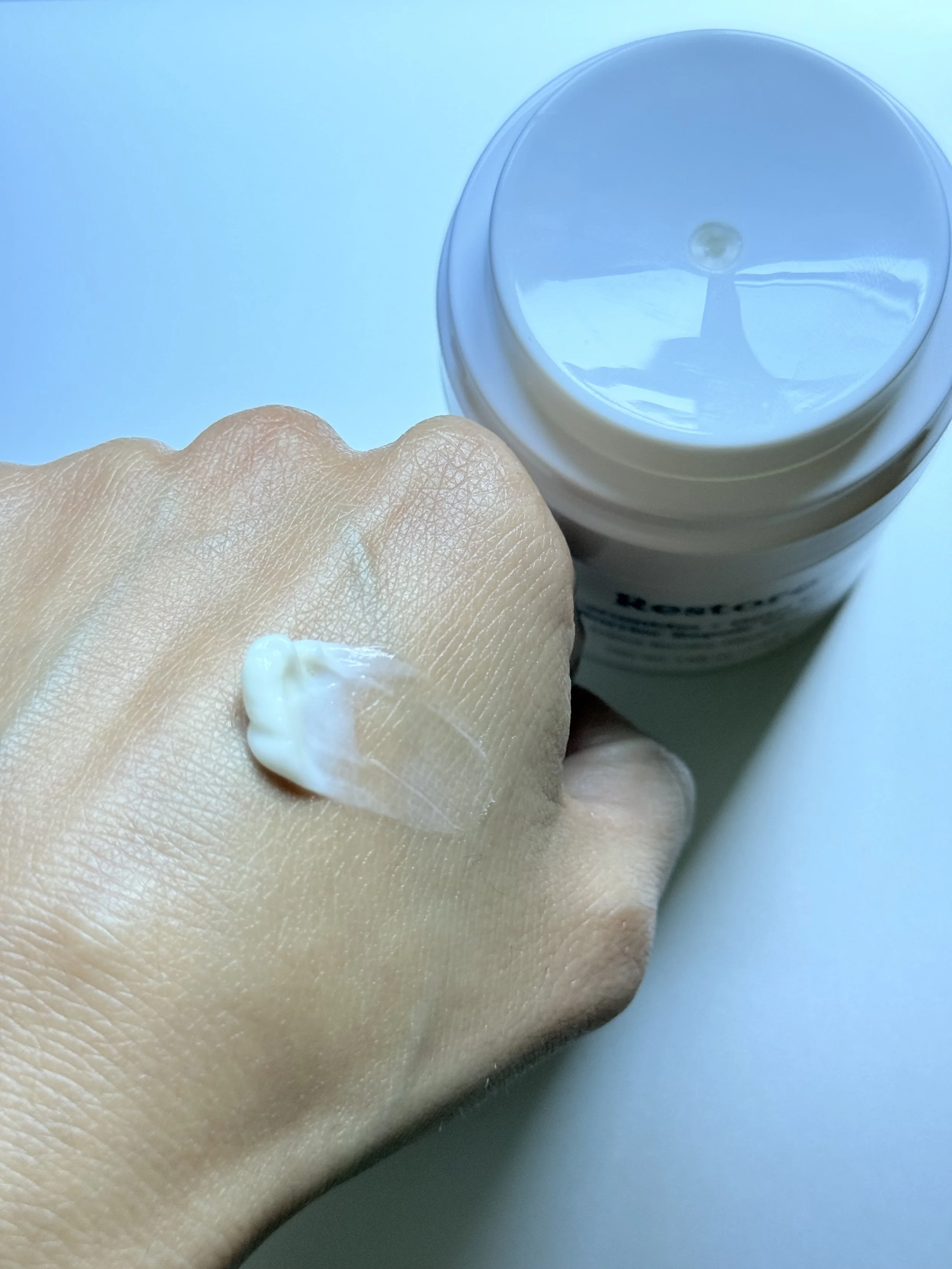 Three Ships Restore Moisturizer swatch beside its packaging