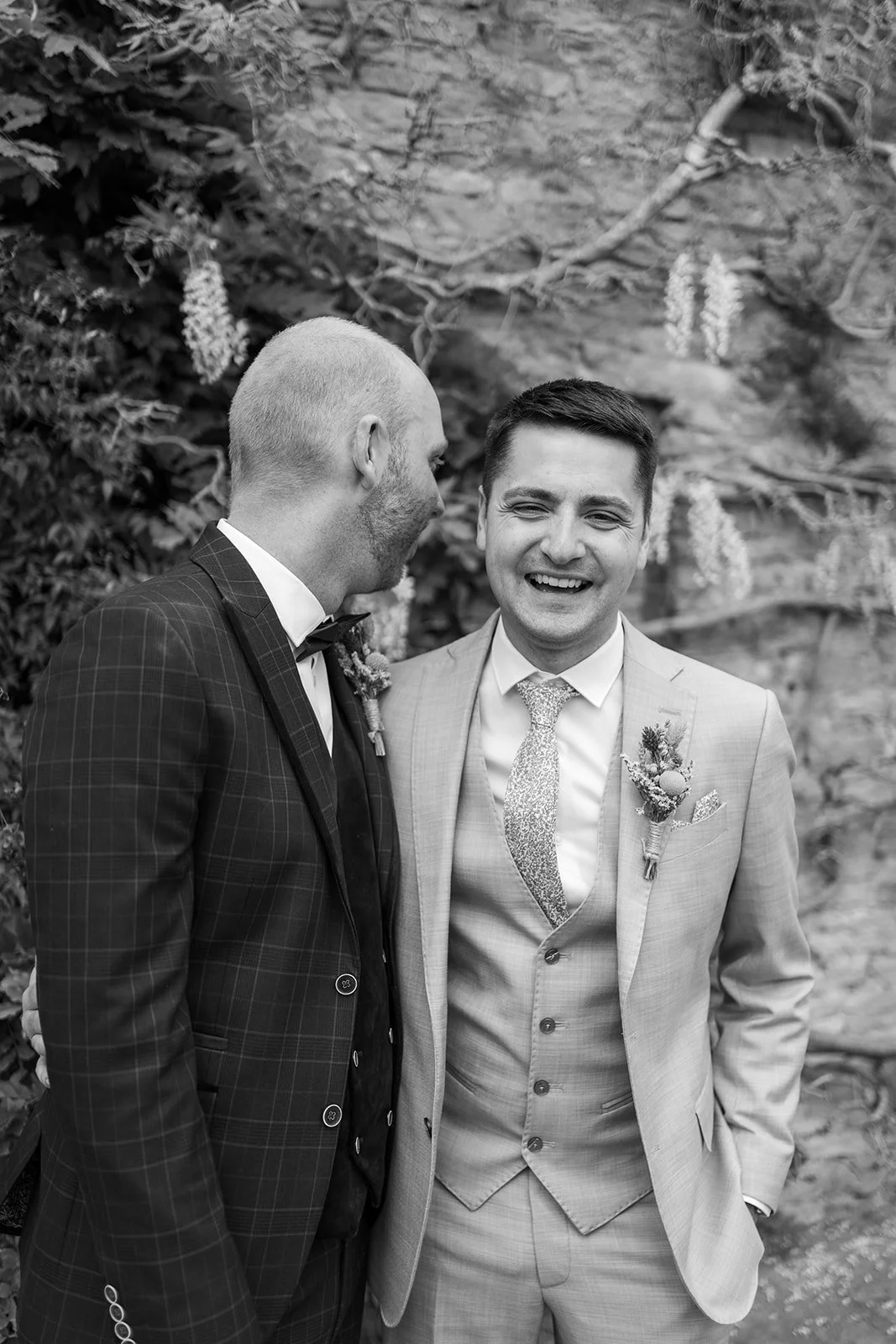 Black and white portrait of Sam & Gavin laughing together at The Great Barn at Aynho in the Cotswolds, photographed by Just James Weddings.