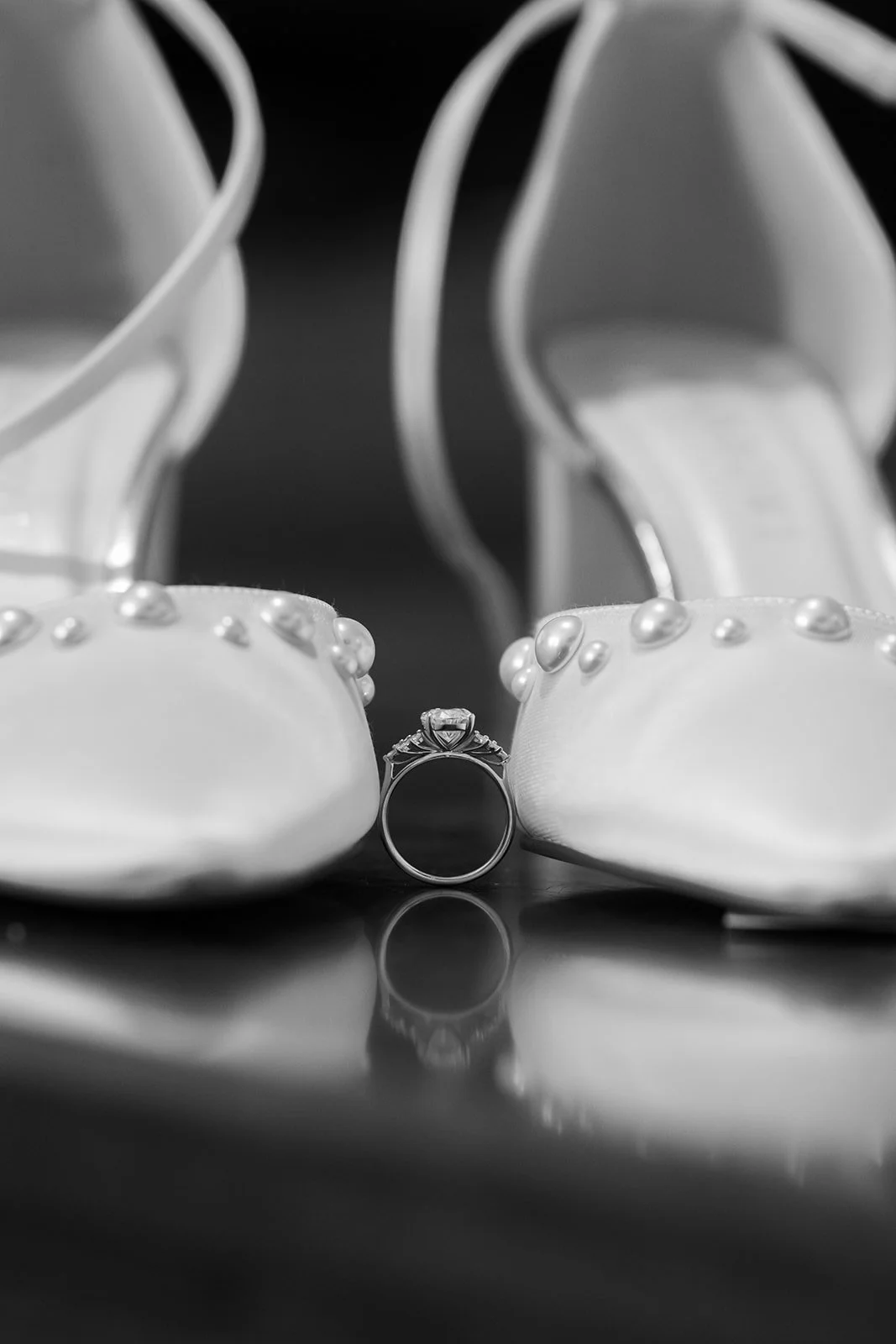 Black and white wedding detail photo of pearl bridal heels with a ring placed between them at Emily & Josh’s wedding at Coombe Lodge Blagdon, Somerset, UK. Elegant close-up of the jewellery and shoes styled for a Somerset wedding morning.