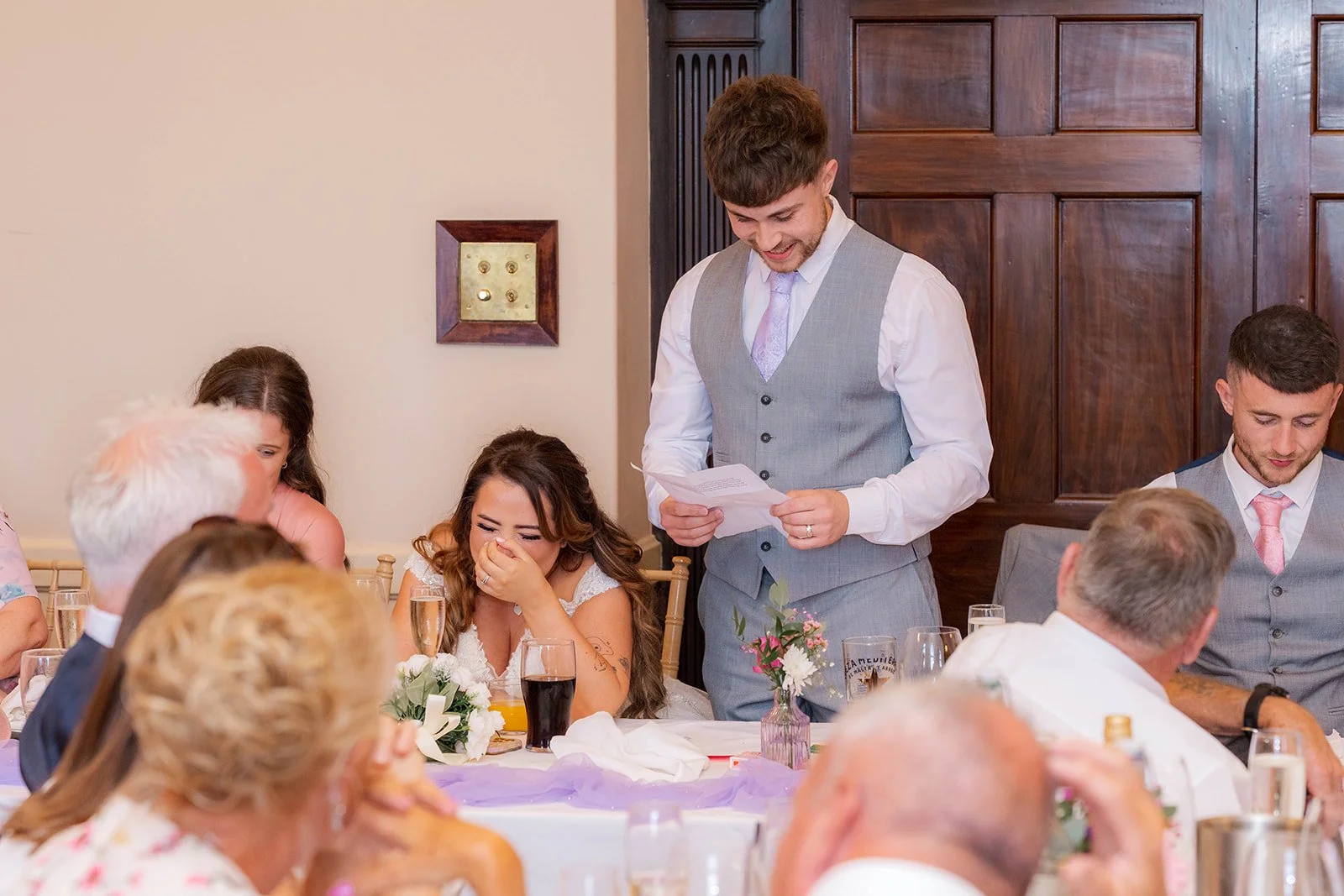 Anthony giving a wedding speech during the reception at Eastwood Park in Gloucestershire, with Rhiannon laughing nearby, photographed by Just James Weddings for candid reception moments.
