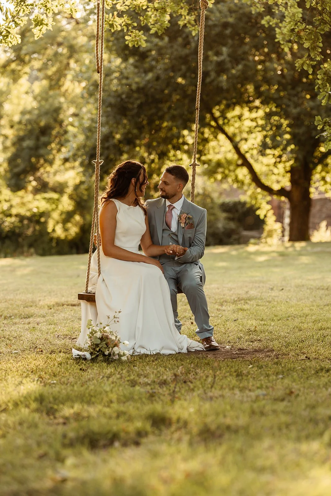Michelle and Andy sit together on a garden swing at Crowcombe Court in Somerset, UK, sharing a quiet moment in the warm evening light.