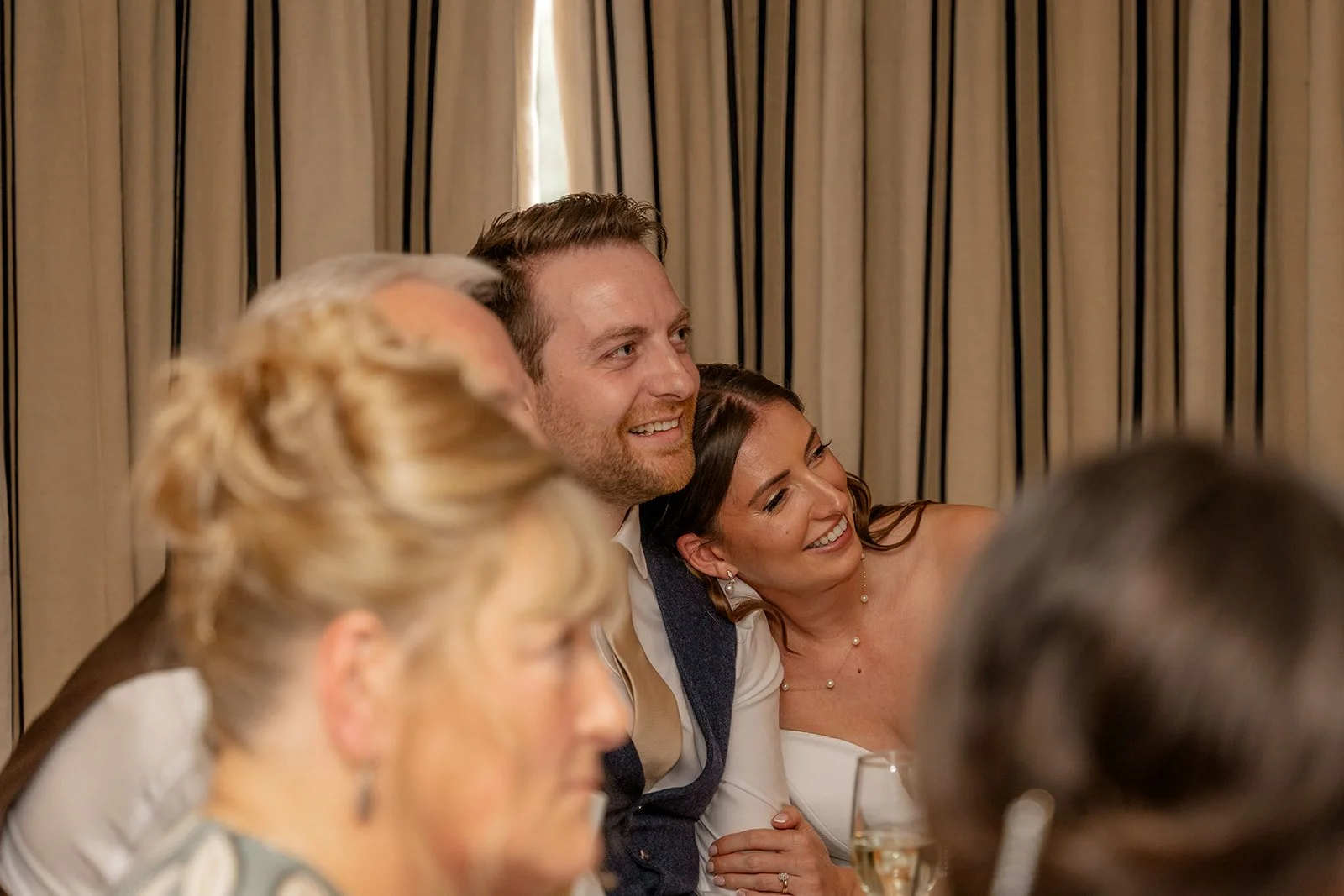 Lilly & Lloyd laughing together during their wedding reception at Broadfield Court in Herefordshire, photographed by Just James Weddings for candid documentary wedding moments.