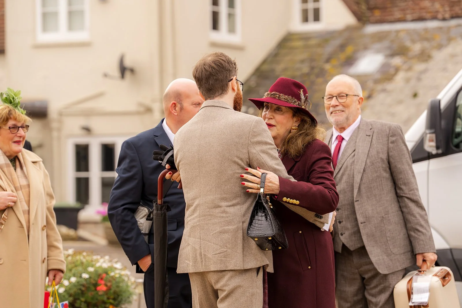 Andrew greeting a wedding guest outside Stockbridge Farm Barn in Dorset before the ceremony, photographed by Just James Weddings for candid autumn wedding moments.