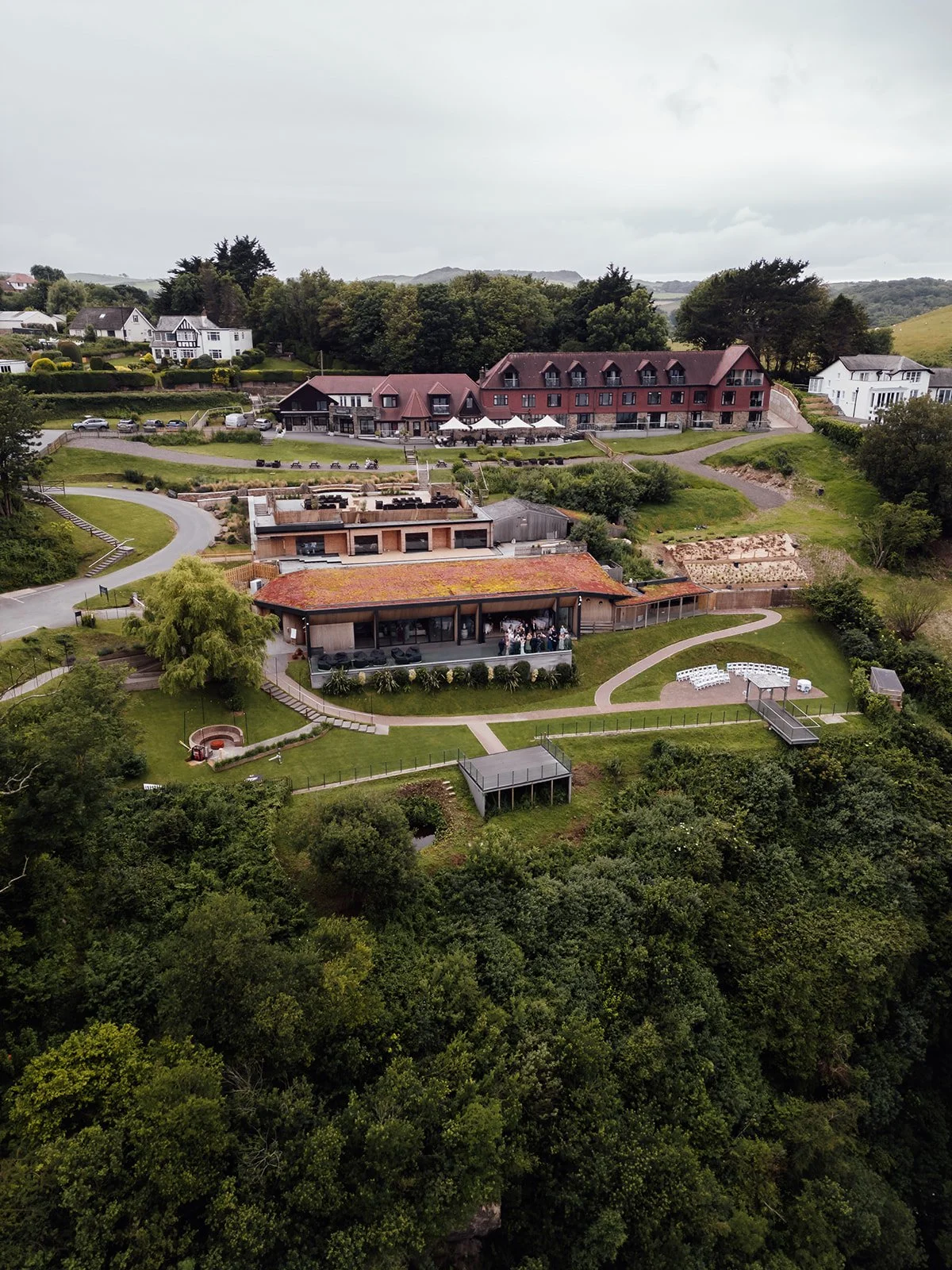 Aerial view of Sandy Cove Hotel, its gardens, outdoor ceremony space and surrounding North Devon countryside during Amy & Connor’s wedding in the UK.
