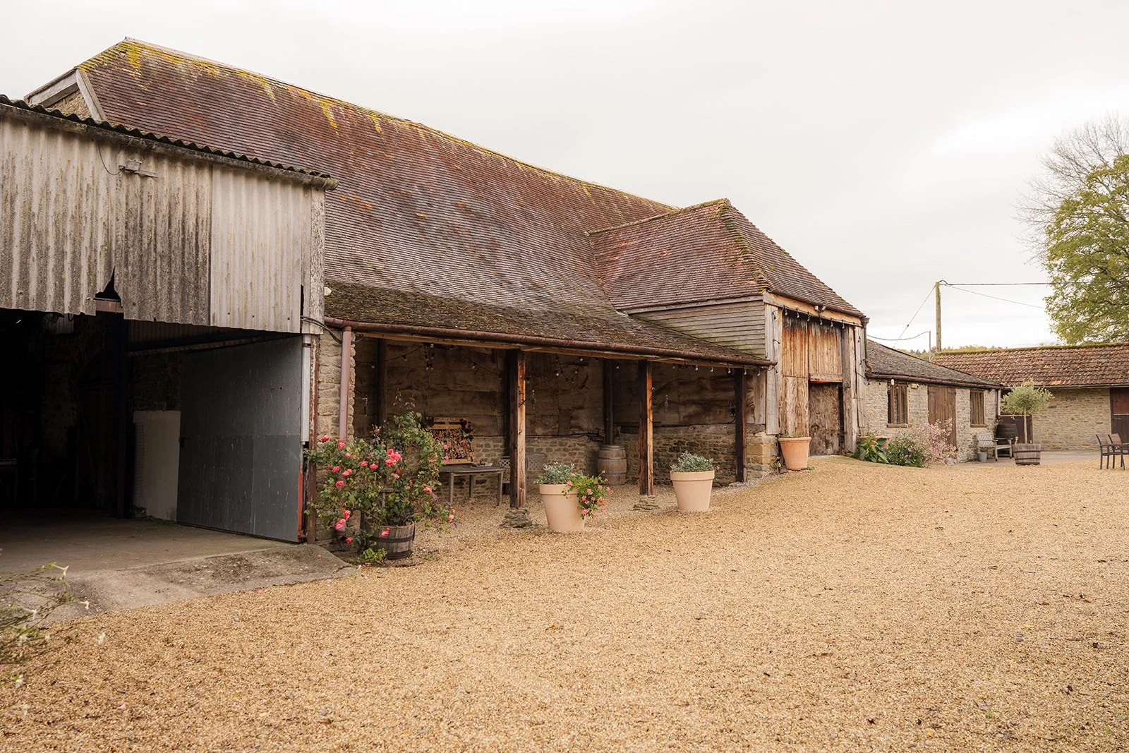 Exterior view of the rustic barns and courtyard at Stockbridge Farm Barn in Dorset, photographed by Just James Weddings for relaxed autumn wedding venue inspiration.