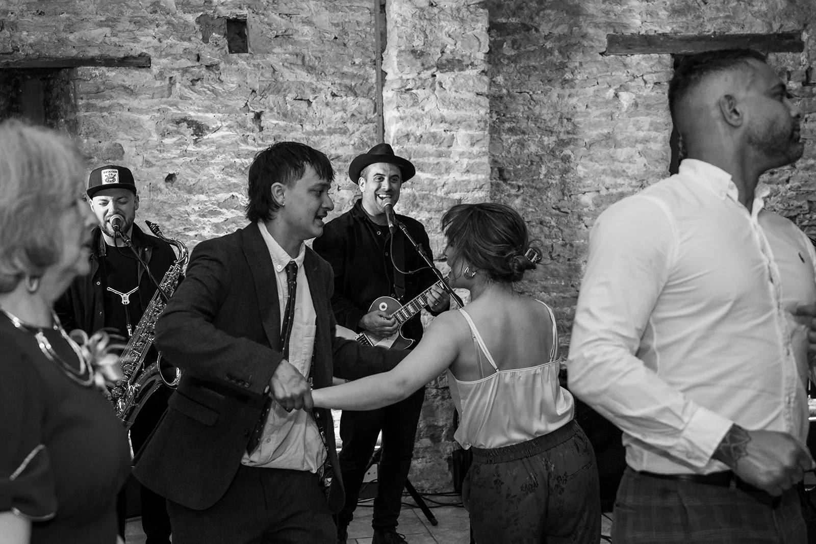 Black and white dance floor photo at Sam & Gavin’s wedding at The Great Barn at Aynho in the Cotswolds, photographed by Just James Weddings for candid evening reception moments.