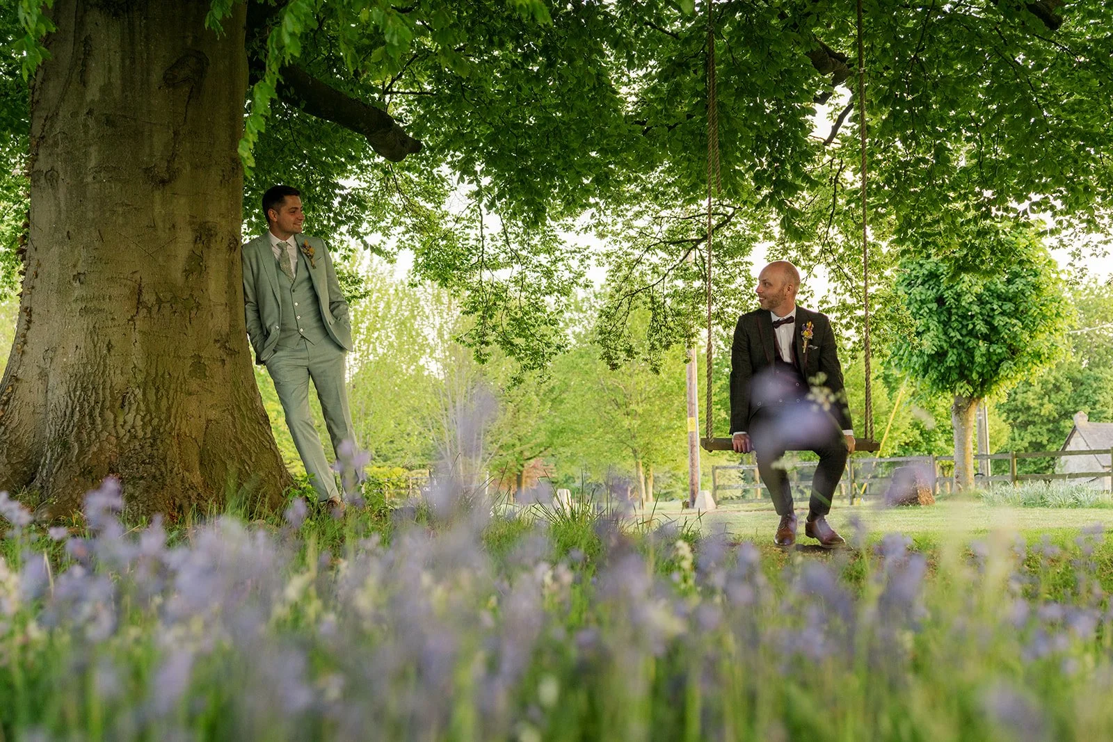 Sam & Gavin enjoying a playful tree swing portrait at The Great Barn at Aynho in the Cotswolds, photographed by Just James Weddings for relaxed wedding photography.