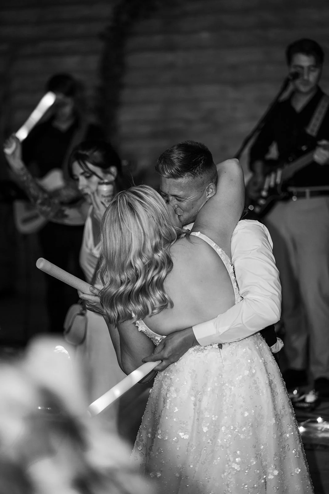 Black and white photo of Elise and Tom kissing on the dance floor during their evening wedding reception at Bowerchalke Barn in Wiltshire, photographed by Just James Weddings.