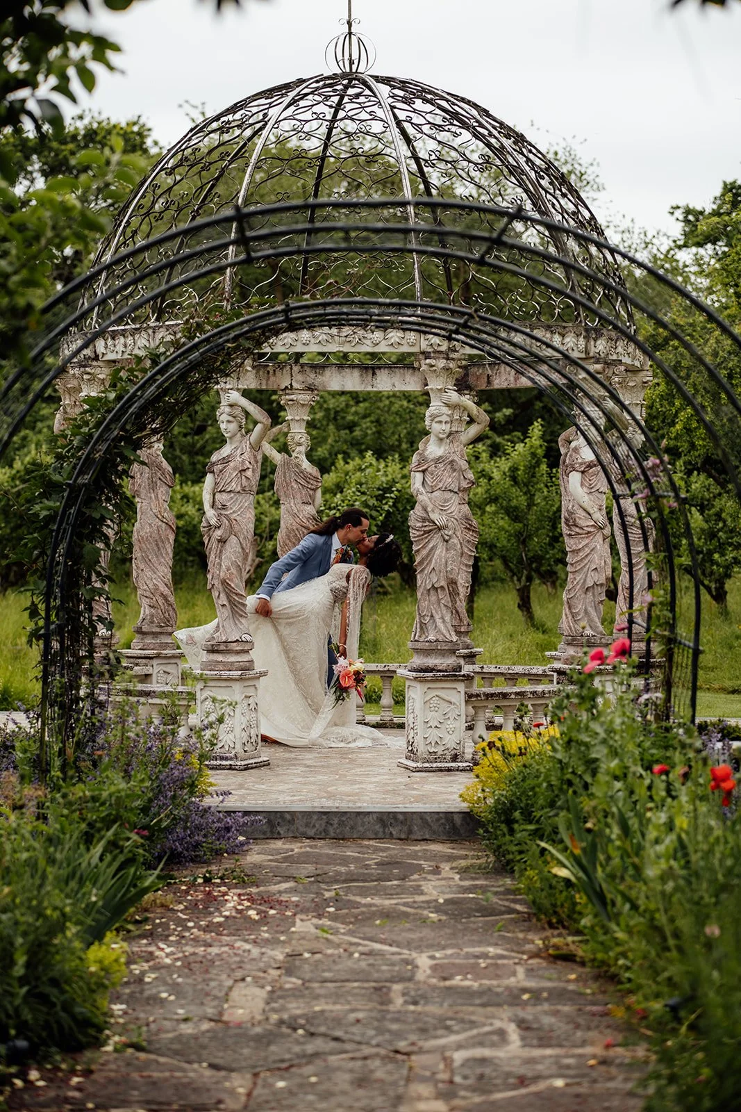 Jonny dips and kisses Melody beneath an ornate garden gazebo at their Berwick Lodge wedding in Bristol, photographed by Just James Weddings.