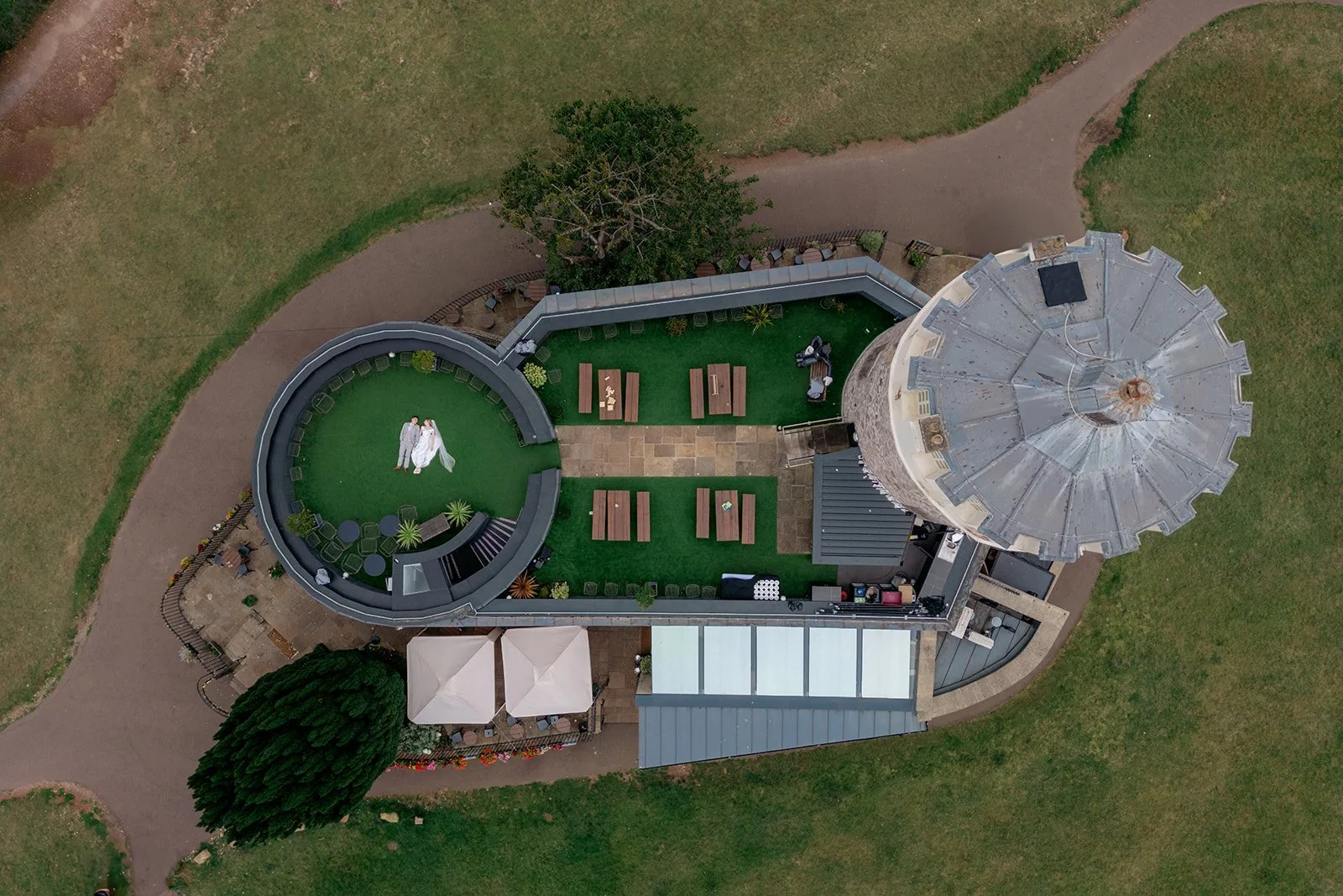 Aerial view of Brian & Josie laying together on the terrace at Clifton Observatory in Somerset, photographed by Just James Weddings for creative wedding portraits and venue inspiration.