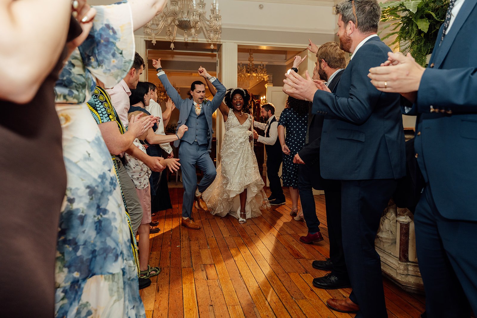 Melody & Jonny dance into their evening reception as wedding guests clap and cheer at Berwick Lodge in Bristol, photographed by Just James Weddings.