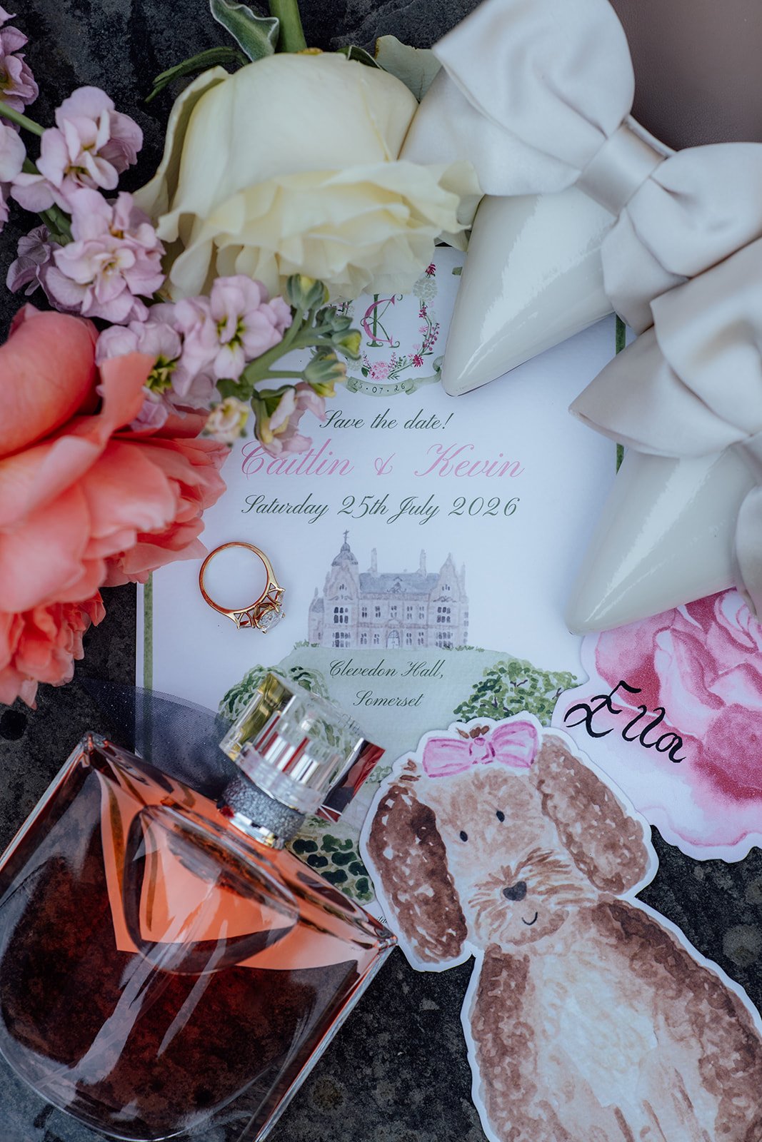 Caitlin and Kevin’s wedding details at Clevedon Hall in Somerset, featuring their save-the-date stationery, engagement ring, white bridal shoes, perfume, flowers and personalised dog illustration.