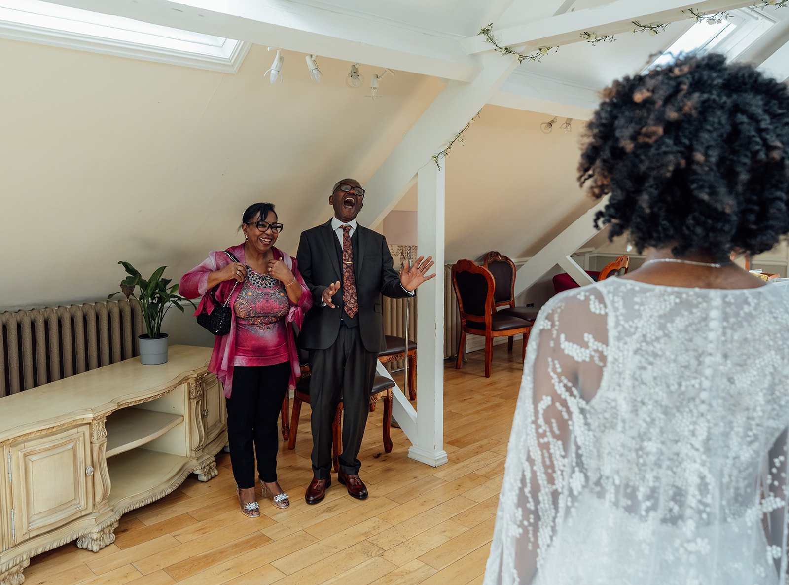 Melody’s parents laugh with delight during a first look with the bride at Melody & Jonny’s Berwick Lodge wedding in Bristol, photographed by Just James Weddings.