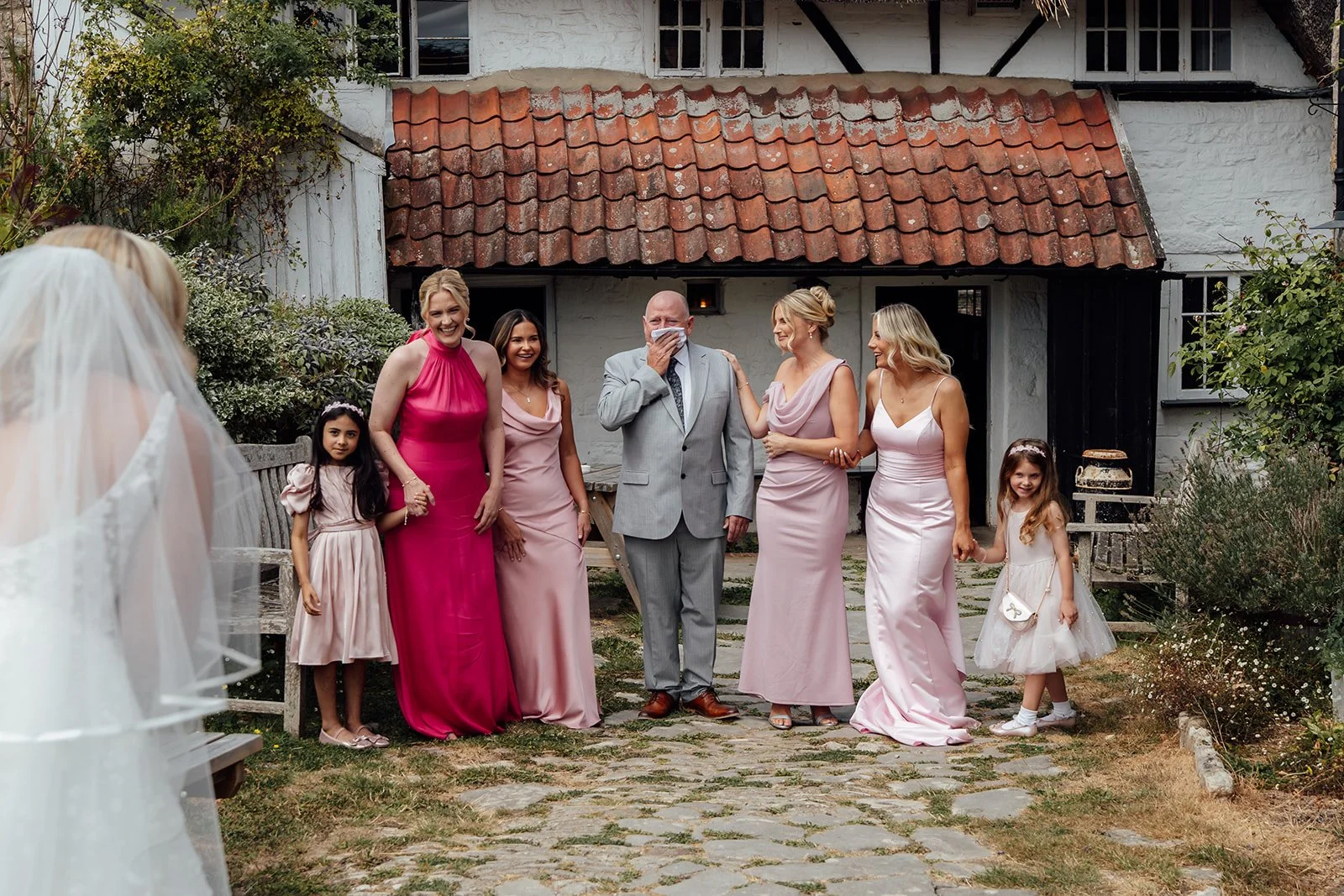 Elise’s family reacting emotionally as they see her in her wedding dress before the ceremony at Bowerchalke Barn, a Wiltshire wedding photographed by Just James Weddings.