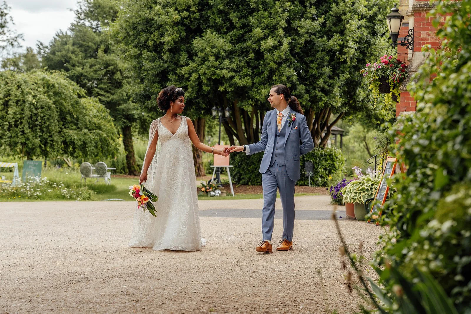 Melody and Jonny walking hand in hand through the gardens during their Berwick Lodge wedding in Bristol, photographed by Just James Weddings.