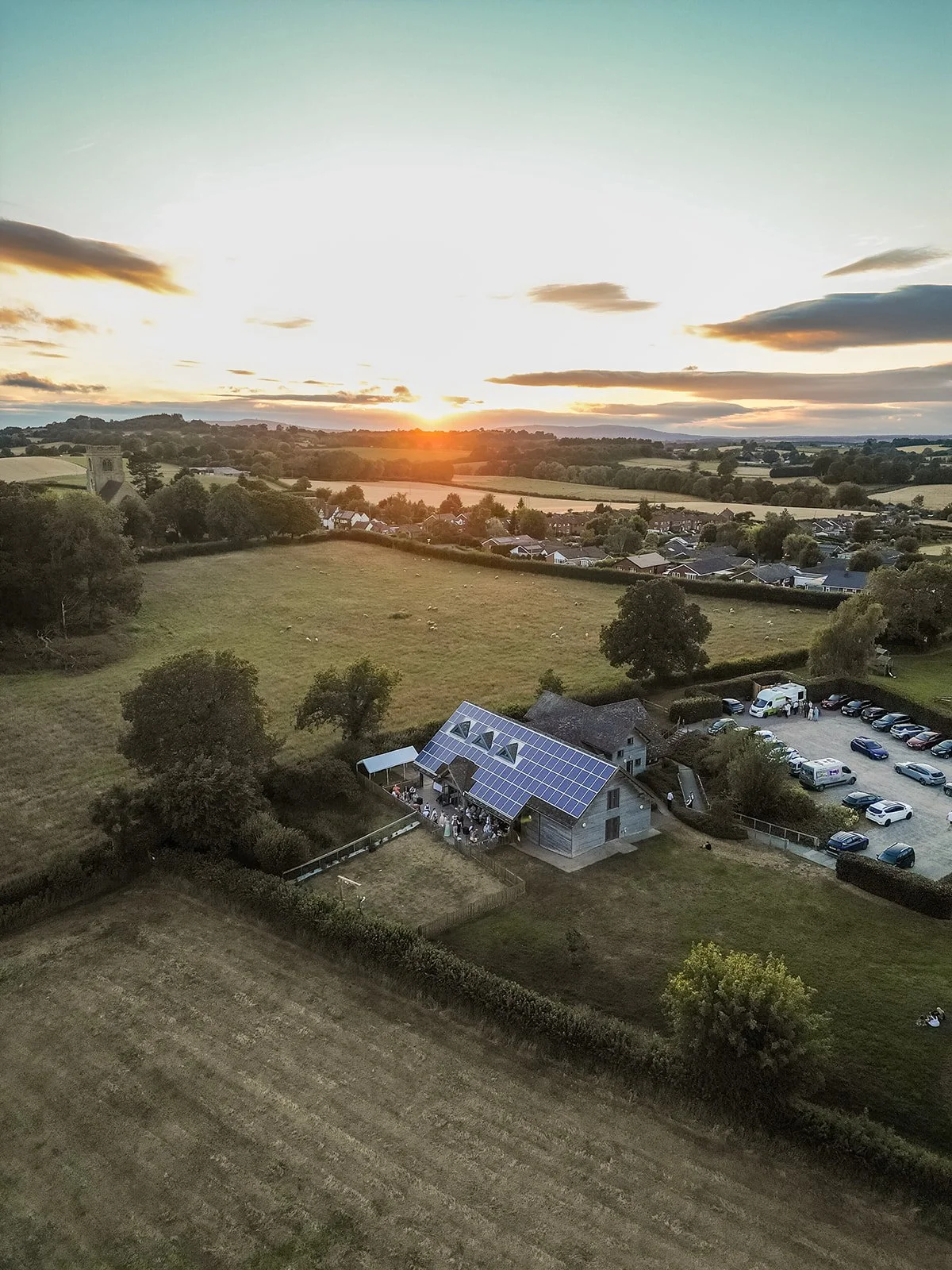 Drone view of Rock Village Hall and the surrounding Worcestershire countryside at sunset during Aaron & Jack’s wedding celebrations, photographed by Just James Weddings.